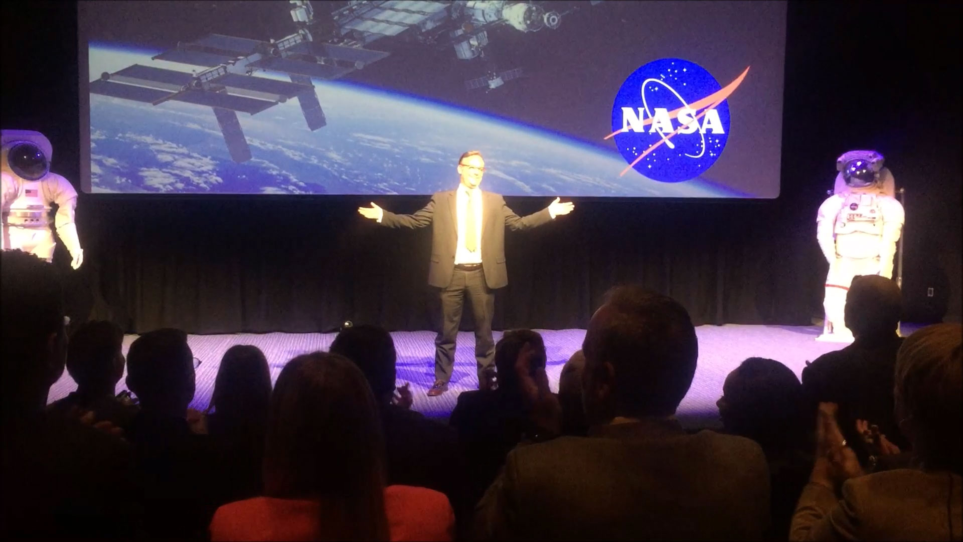 Prof. Christian Farioli on stage with a NASA backdrop